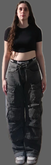 a woman in a black top and cargo pants